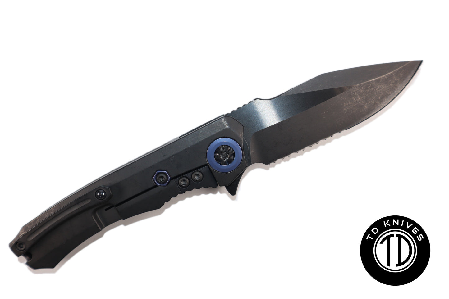 HERETIC-  Wraith Manual V3 in Titanium Chassis, Carbon Fiber Inlays W/ DLC Serrated Battleworn MagnaCut Blade & Blue Ti Accents Model # H001-6B-BLUTi