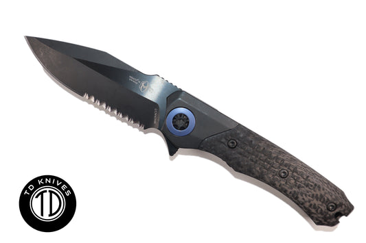 HERETIC-  Wraith Manual V3 in Titanium Chassis, Carbon Fiber Inlays W/ DLC Serrated Battleworn MagnaCut Blade & Blue Ti Accents Model # H001-6B-BLUTi